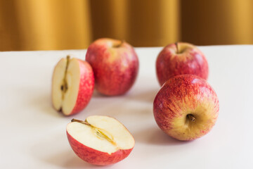 Apples on a white table over a yellow curtain background, horizontal