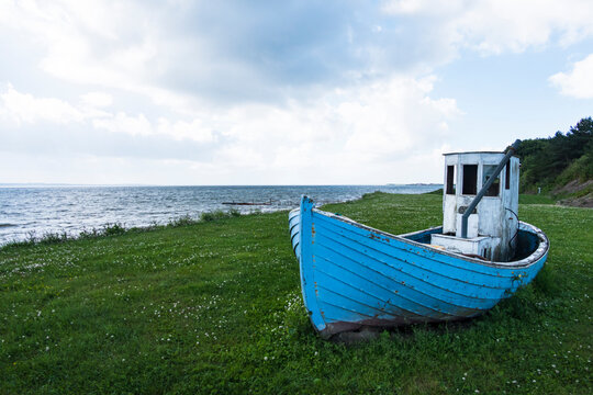Ejerslev, Denmark, A small wrecked fishing boat sits on the grass at the entrance to the Ejerslev port.
