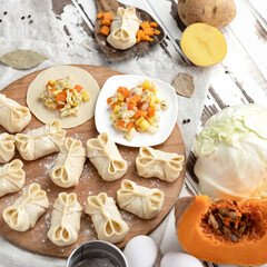 Cooking process. Dumplings stuffed with pumpkin, potato and cabbage. Convenience Food. Slices of raw dough with filling on wooden cutting board. Top view. Square format. Soft focus.