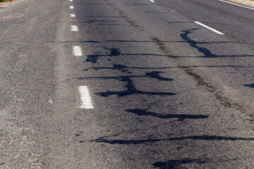 part of an asphalt road with damage