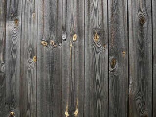 The texture of wooden planks arranged vertically. The color of the boards is gray with yellow splashes.