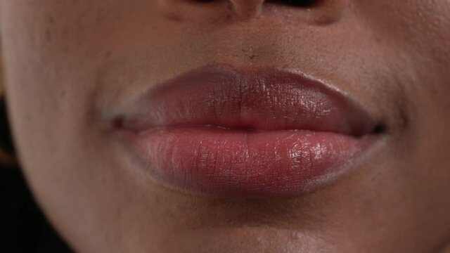 Close up of an African woman's mouth pouting to the camera