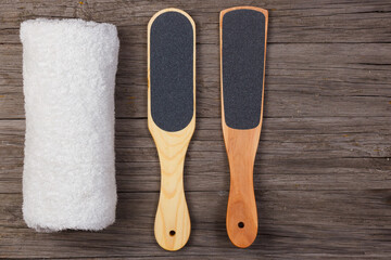 Pedicure grater with a towel on a wooden background. Top view