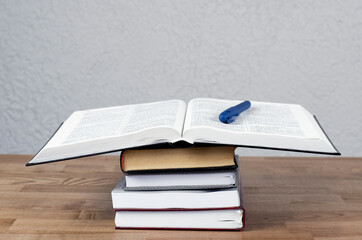 Open Bible. A stack of books on the table. Education. Training.