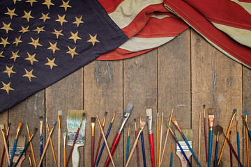 Antique American flag drapped on an old work bench with artists brushes