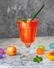 Orange soft drink in a tall glass with cocktail tube