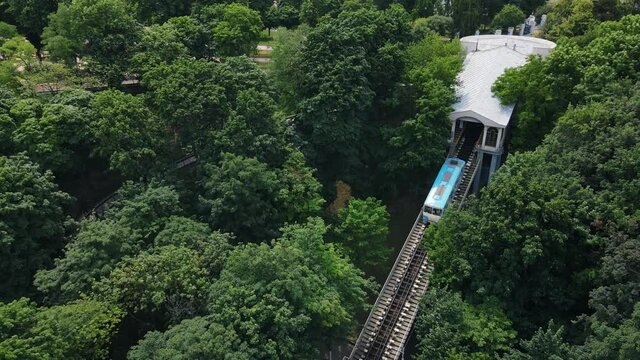 Aerial view of funicular in a park area with tourists going down to the station
