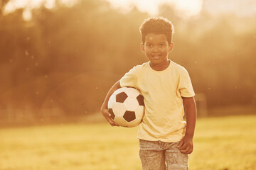 Young soccer player. African american kid have fun in the field at summer daytime