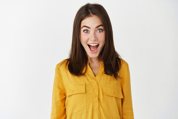 Close-up of happy and surprised woman open mouth and staring with disbelief, receive good news,...