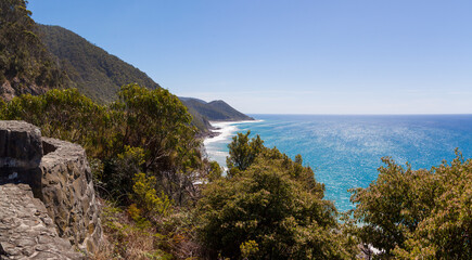 Panorama from the Great Ocean Road in Australia to the blue ocean and hilly coast on a sunny day with a distant perspective. Views from the road during the trip.