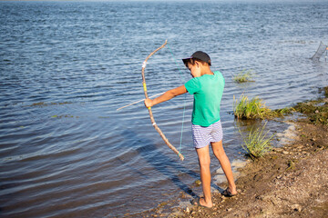Little archer hunting fish on the river bank