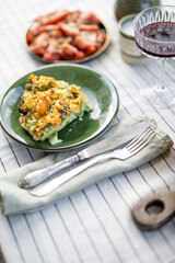A piece of cheese pie on green plate on table covered with a tablecloth. Summer dinner outdoor. 