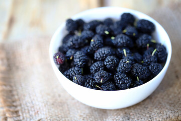 Selective focus. Fresh mulberry berries in a bowl.
