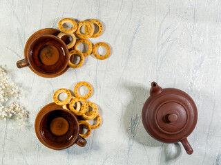 Table set for Russian tea with bagels, ceramic teapot with a couple of cups, top view