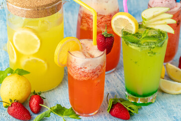 refreshing lemonade with lemon, strawberry and mint on blue background