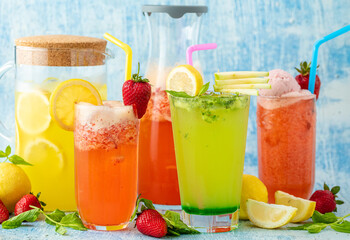 refreshing lemonade with lemon, strawberry and mint on blue background