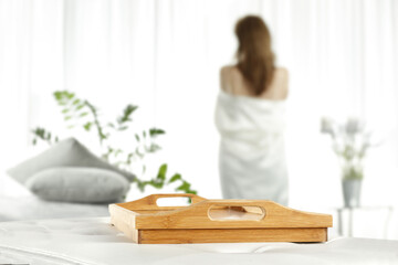 Brown wooden tray of free space for your deocration and slim young woman with window 