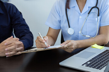 patient consulting a female doctor at a desk of medical concepts