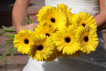 Gelbe Blumen in der Hand einer Braut