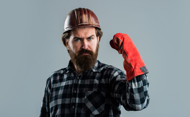 bearded male hipster in checkered shirt and laborer helmet, working uniform