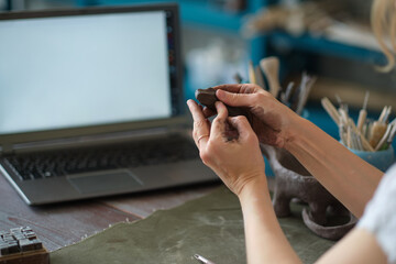 artisan pottery tutor in art studio. woman ceramist teaches an online lesson or leads a video master class on creating ceramic products