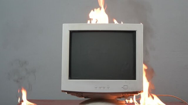 An old computer monitor is on fire. Fire hazardous situation in the apartment, causes of fire, short circuit.