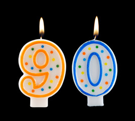 Burning birthday candles isolated on black background, number 90
