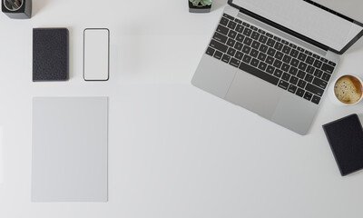Workspace top view with a laptop and the blank white screen of a monitor for mockup.