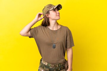 Military caucasian woman with dog tag isolated on yellow background having doubts and with confuse face expression