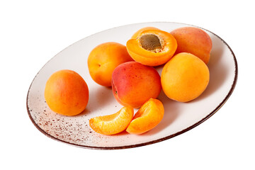Fresh ripe whole  and sliced apricot fruits  on vintage plate isolated on white