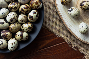 Close up of quail's eggs on dark plate on wood; small birds eggs; delicacy; gourmet cooking ingredient