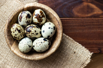 Close up of quail's eggs in wooden bowl and wooden background; delicacy; gourmet ingredient; small...