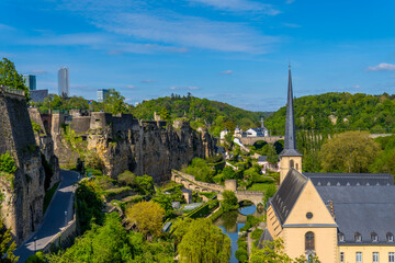 Vertical view of Luxembourg-City with Neumünster abbey, medieval houses in the lower city, trees, and Kirchberg skyline in the background