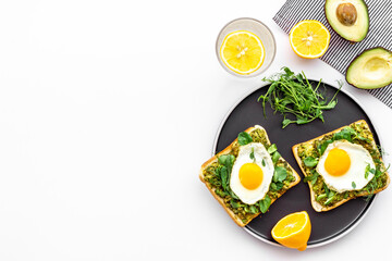 Breakfast with toasts of fried eggs and avocado saurce. Top view