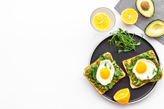 Breakfast with toasts of fried eggs and avocado saurce. Top view