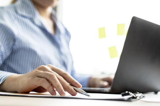 A businesswoman is reviewing the sales summary sheet from the sales department, she is reviewing the data and analyzing the sales data to plan to manage more sales growth. Sales management concept.