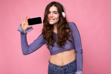 Beautiful happy smiling young woman wearing stylish casual outfit isolated on background wall...