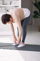 athletic mature woman exercising at home, active lifestyle, 84 years old lady workout