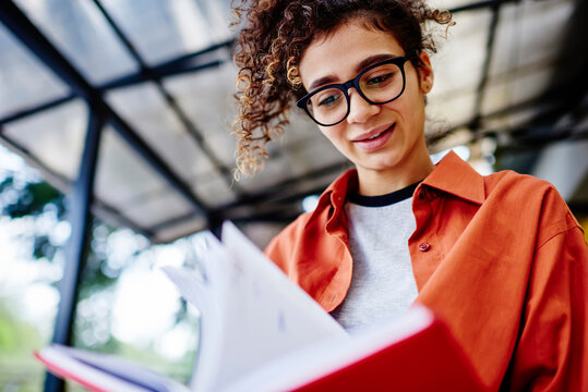 Dreamy woman flipping pages in notebook