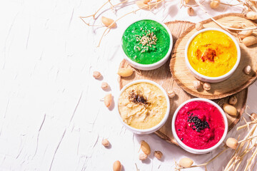 Various hummus dips, the flat lay of hummus in different colors with spinach, beetroot, turmeric and vegetables