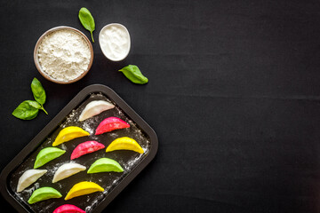 Chinese colorful raw dumplings on baking sheet, top view