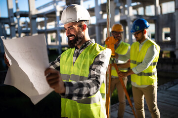 Construction engineers discussion with architects at construction or building site