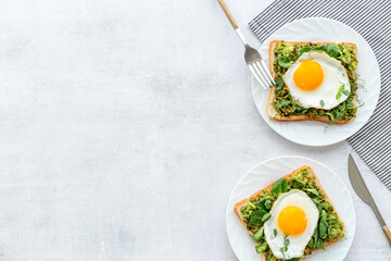 Breakfast with avocado toasts and fried eggs, top view