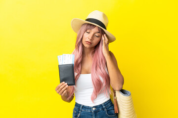 Young mixed race woman holding passport and beach bag isolated on yellow background with headache