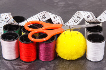 Accessories and tools for using in sewing. Spools of thread, needle, scissors and centimeter