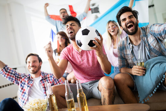 Group of friends having fun at home, watching game and enjoying together.