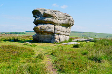 Close up of the Eagle Stone gritstone outcrop behind Baslow Edge on a misty summer morning