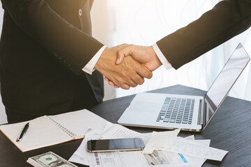 Image of two young businessmen using touchpad at meeting