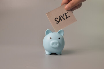 Man hand putting save note into piggy bank. Saving money concept.