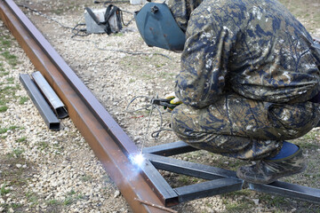 Workers weld metal for sliding gates.